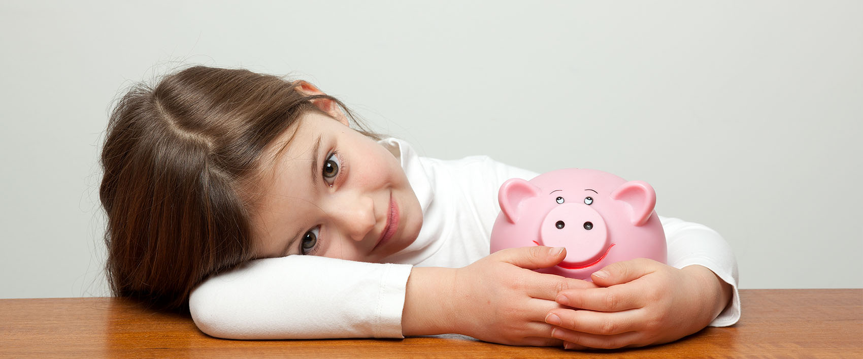 Young girl holding a piggy bank